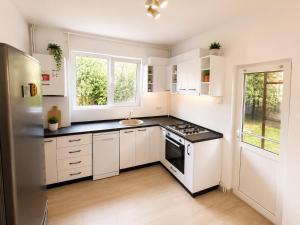 a kitchen with white cabinets and a black counter top at Vila Ioana in Ştefăneşti