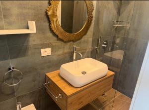 a bathroom with a white sink and a mirror at I Trulli di Federico in Selva di Fasano +22 photos