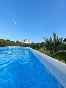 a large swimming pool with blue water at I Trulli di Federico in Selva di Fasano