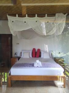 a bedroom with a bed with a canopy at Pondok Alam Bukit in Tirtagangga