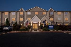 a large house with a sign in front of it at Microtel Inn & Suites - Greenville in Greenville