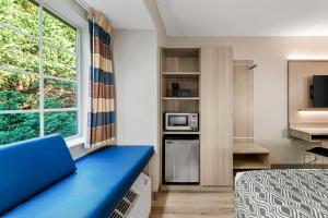 a small room with a bed and a window at Microtel Inn & Suites - Greenville in Greenville