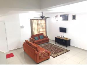 a living room with a couch and a tv at MARMA Homestay Melaka in Ayer Keroh