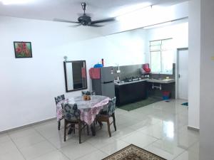 a kitchen with a table with chairs and a sink at MARMA Homestay Melaka in Ayer Keroh