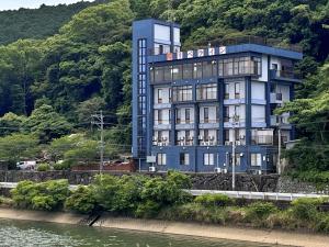 a blue building on the side of a river at Ribera Inn in Satsumasendai