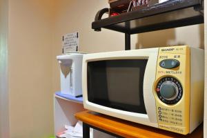 a microwave sitting on top of a wooden table at Ribera Inn in Satsumasendai
