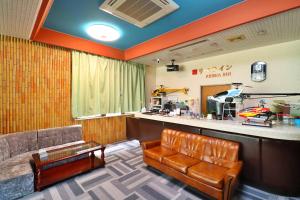 a waiting room with a couch and a bar at Ribera Inn in Satsumasendai