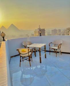 a table and chairs on the roof of a building at malak pyrameds rofe top in Cairo