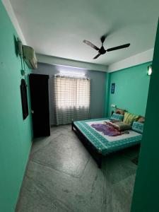a bedroom with a bed and a ceiling fan at Subba Stays in Siliguri