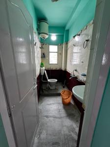a bathroom with a toilet and a sink at Subba Stays in Siliguri