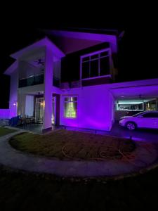 a house with purple lights in the night at Villa Hayfa in Kuala Kerai +6 photos