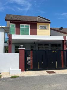 a large house with a black garage door at Villa Hayfa in Kuala Kerai