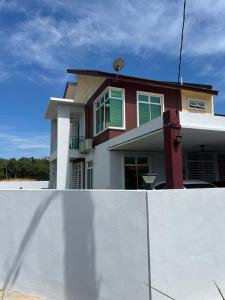 a house with a white fence in front of it at Villa Hayfa in Kuala Kerai