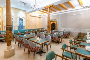 a dining room with tables and chairs and a whiteboard at Khan Hotel Bukhara Old Town in Bukhara