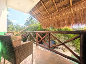 ein Balkon einer Villa mit Strohdach in der Unterkunft Hostel Humanity - Puerto Morelos in Puerto Morelos
