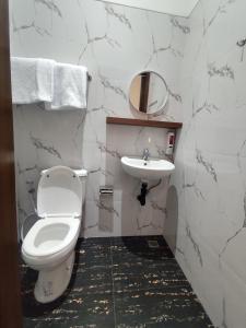 a bathroom with a white toilet and a sink at Moonrise Rooms in Uluwatu +11 photos