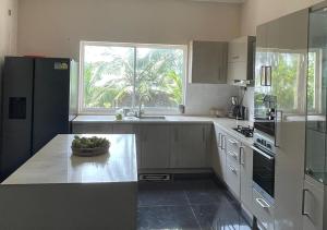 a kitchen with a black refrigerator and a window at Palm Breeze Villa in Mannar
