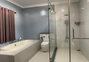 a bathroom with a tub and a toilet and a shower at Palm Breeze Villa in Mannar