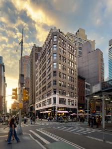 a city street with people crossing the street in front of a building at NoMad Studio Near Broadway & Madison Square in New York