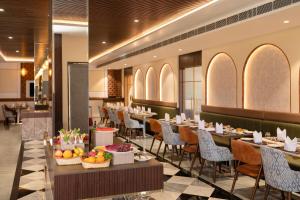 a restaurant with tables and chairs with fruit on them at Enrise By Sayaji Somnath in Somnath