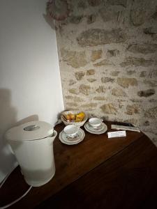 a table with a bowl of fruit and a toilet at Ancien hôtel du Thaurion in Saint-Hilaire-le-Château