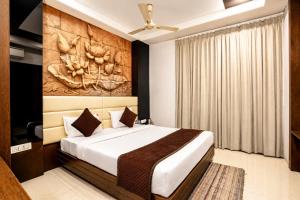 a bedroom with a bed with a painting on the wall at Hotel Sawamani - 100 Meters from Khatushyam ji in Khātu +71 photos