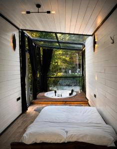 a bed in a room with a bath tub at MOLVA Bungalows Otel in Çamlıhemşin
