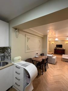 a kitchen and living room with a table and a couch at Warm Flat in Gonio