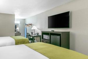 a hotel room with two beds and a flat screen tv at Rodeway Inn Kingston Springs in Kingston Springs