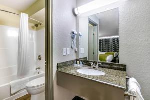 a bathroom with a sink and a toilet and a mirror at Rodeway Inn Kingston Springs in Kingston Springs +23 photos