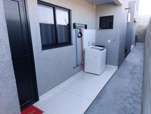 a bathroom with a small refrigerator and a window at Gk-Hospedagem in Foz do Iguaçu