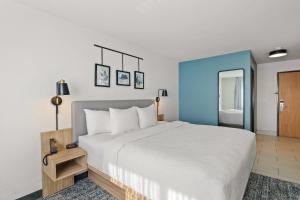 a bedroom with a white bed and a blue wall at Sleep Inn & Suites Verona - Madison Southwest in Verona +59 photos