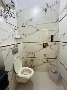 a white bathroom with a toilet and a sink at Hotel Prithvi Studio - RDC And Santosh Hospital in Ghaziabad
