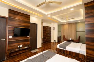 a bedroom with a bed and a flat screen tv at Hotel Sawamani - 100 Meters from Khatushyam ji in Khātu