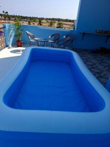 a blue swimming pool on a patio with chairs at Journeyman Ocean Deck in Marakkānam