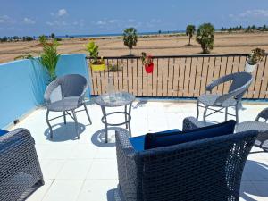 a patio with chairs and tables and a view of the beach at Journeyman Ocean Deck in Marakkānam