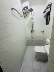 a white bathroom with a toilet and a shower at April shortlet apartments in Lagos