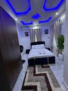 a bedroom with blue ceilings and a bed with a rug at April shortlet apartments in Lagos