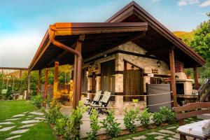 a house with a porch with chairs in the yard at Студио Мурите in Sapareva Banya +5 photos