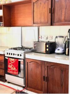 a kitchen with a stove top oven in a kitchen at AWESOME HOME's in Arusha