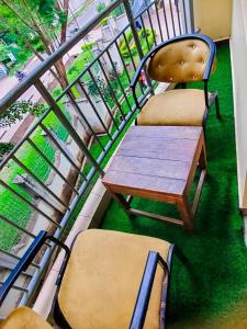 a balcony with two chairs and a wooden table and chairs at AWESOME HOME's in Arusha