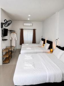 a group of three beds in a room at Yada House Cozy Place in Nai Yang Beach