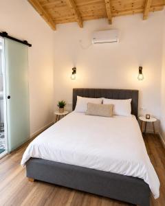 a bedroom with a large bed and two tables at Villa Keren in Oropos