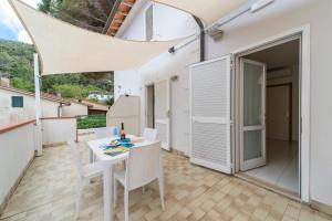 a small balcony with a white table and chairs at Residence Hotel Villa Mare in Portoferraio