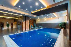 a large swimming pool in a building with a pool at Golden Palace Hotel in Tbilisi City