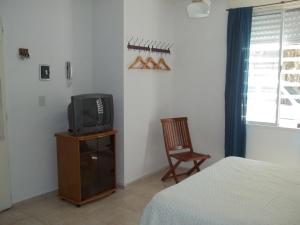 a bedroom with a bed and a tv and a chair at Apartamento Pichincha Rosario in Rosario