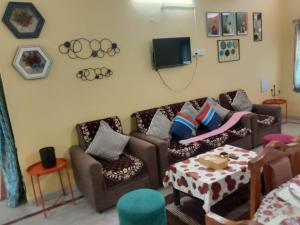 a living room with couches and a table and a tv at Two BHK and Four BHK Fully Furnished Flats for 1 to 13 guests - Near Charminar and Salar Jung Museum in Hyderabad