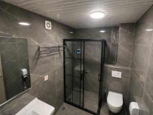 a bathroom with a shower and a toilet and a sink at Grand Mardin Hotel in Mersin
