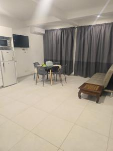 a living room with a table and chairs and a refrigerator at Beach 2 Min - Bright Central Studio - AC in Santa Maria