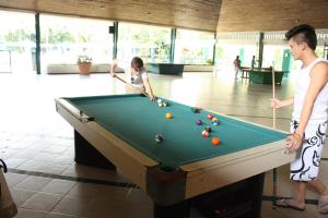 Hotel Guadaira Resort في ميلغار: a woman and a girl playing a game of pool